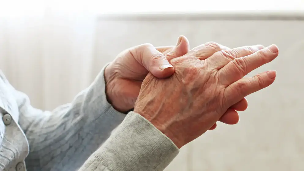 Elderly woman applying moisturizing lotion cream on hand palm, easing aches. Senior old lady experiencing severe arthritis rheumatics pains, massaging, warming up arm