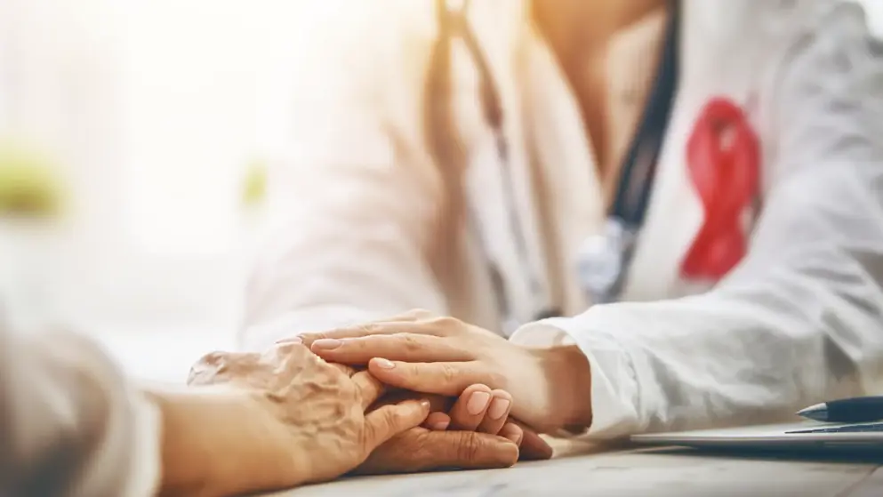 Doctor holding patients hand in consultation