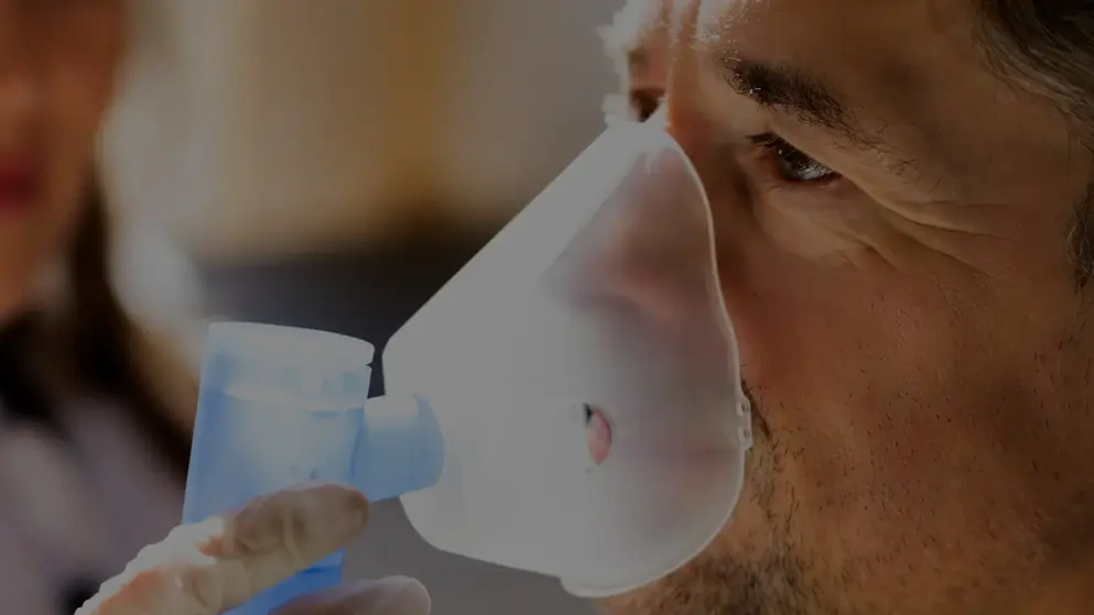 A young man using a nebuliser to assist with COPD