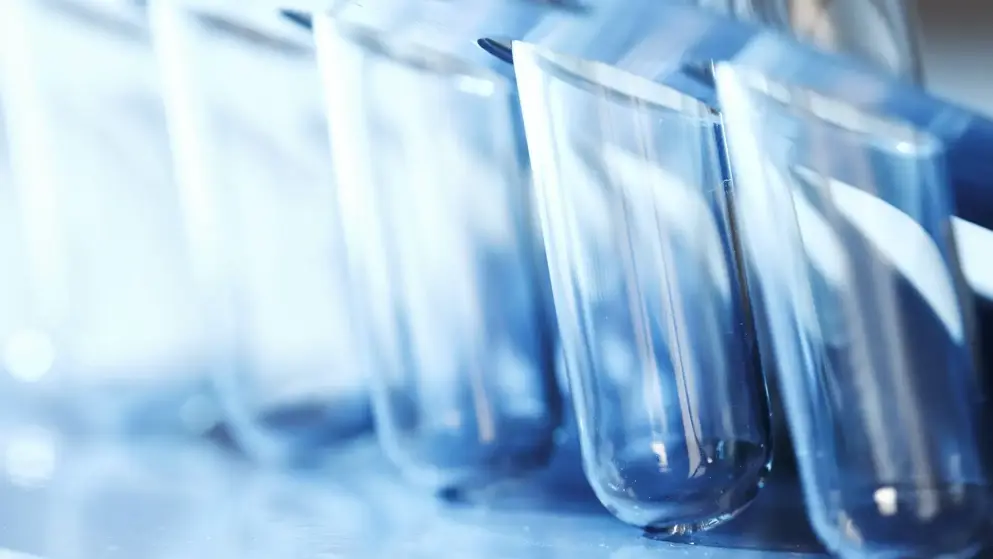 Blue test tubes arranged in a line, disappearing into the background