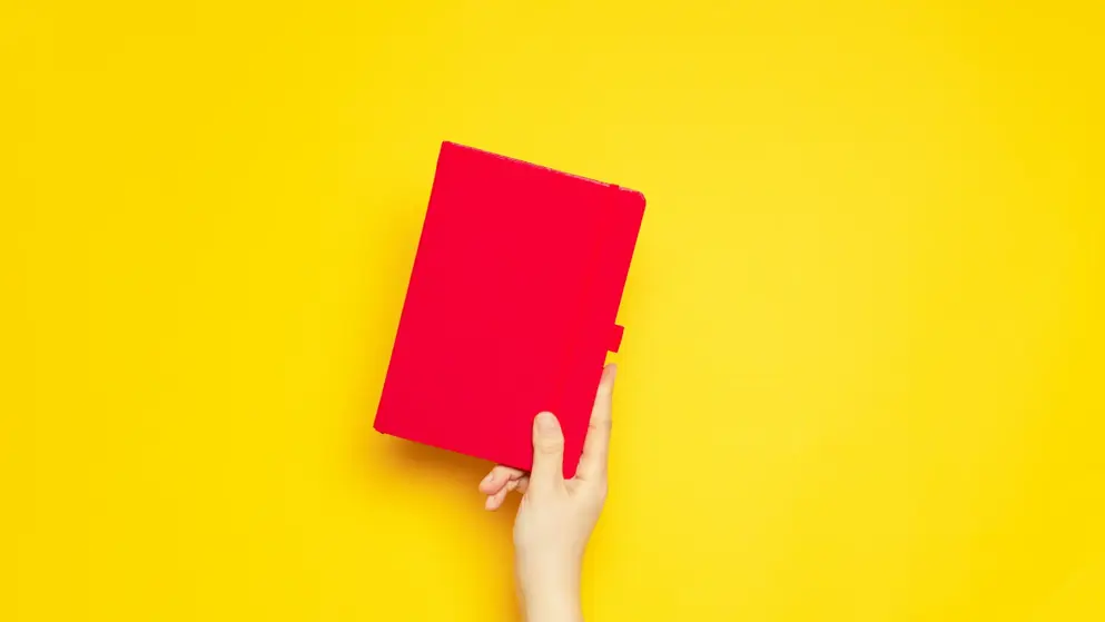 Red notebook on yellow background.